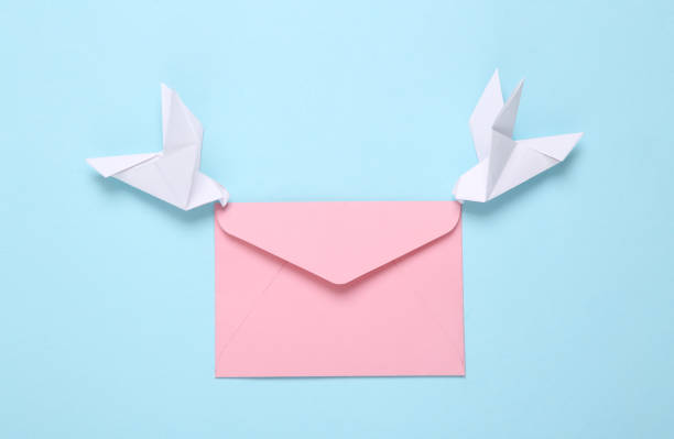istock Origami carrier pigeons with envelope on a blue background 1334645356