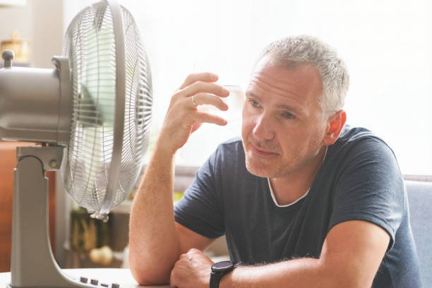 istock Man suffers from heat at home 1334652526