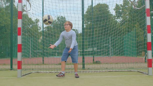 istock Down syndrome boy attention training. Catching ball is an exercise of agility. 1334653635
