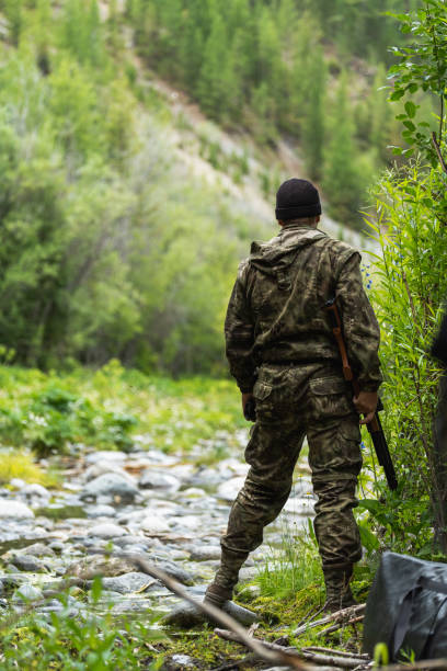 istock A man in a comuffle with a rifle in his hands looks forward. Duck hunting. 1334653786