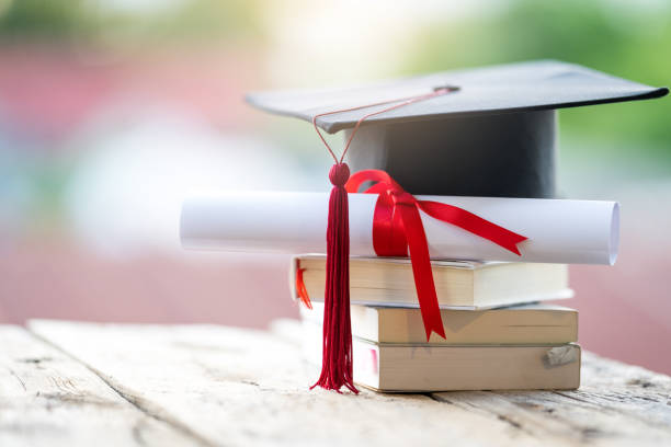 istock Close-up selective focus of a graduation cap or mortarboard and diploma degree certificate put on the table 1334653942