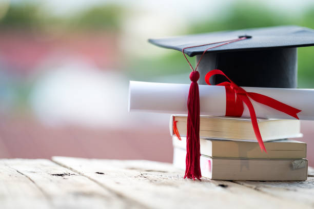 istock Close-up selective focus of a graduation cap or mortarboard and diploma degree certificate put on the table 1334653984