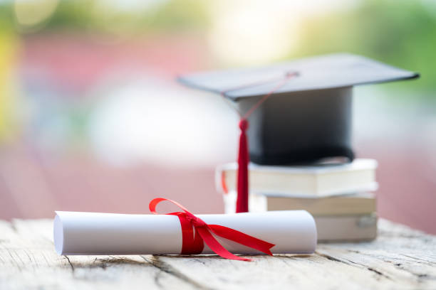 istock Close-up selective focus of a graduation cap or mortarboard and diploma degree certificate put on the table 1334654097
