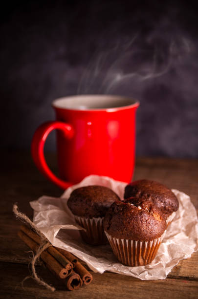 istock Fresh chocolate muffins and cinnamon sticks on rustic wooden background 1334655612