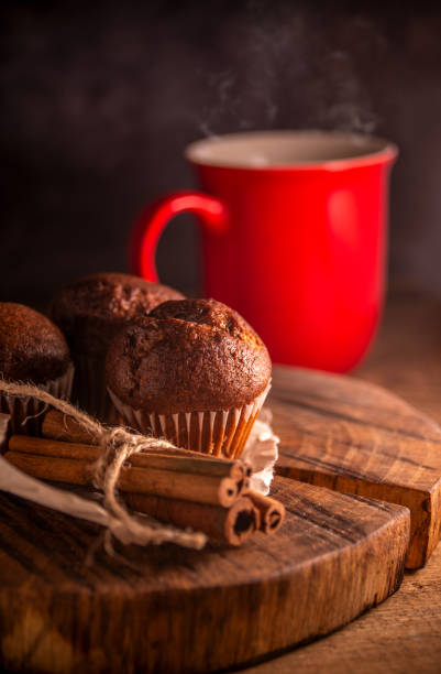 istock Fresh chocolate muffins and cinnamon sticks on rustic wooden background 1334655627