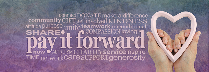 campaign banner with female hands holding a heart frame on right with a PAY IT FORWARD word cloud beside on a rustic parchment background