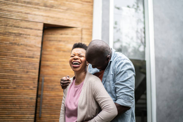 Happy couple embracing in front o new house
