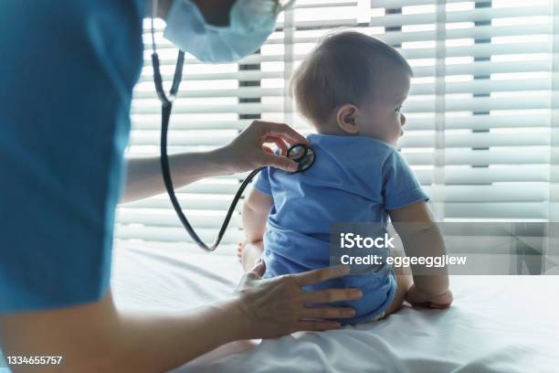 Asian Female Pediatrician Doctor Examining Her Little Baby Patient With Stethoscope In Medical Room Stock Photo - Download Image Now