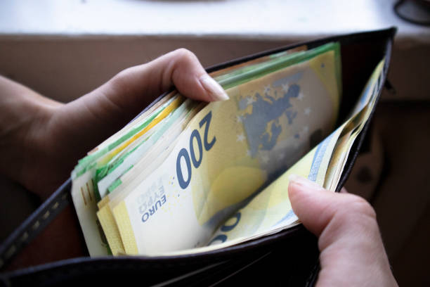 Woman Showing Euro Currency Notes From Her Purse European Union currency, Savings, Wallet, Shopping, Buying european union currency european union euro note currency europe stock pictures, royalty-free photos & images