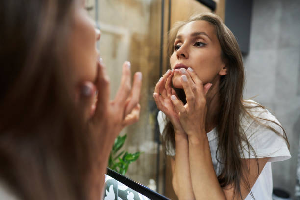 istock Woman checking face condition in the mirror 1334657227