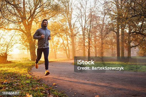 istock Adult male runner in park at autumn sunrise 1334658317