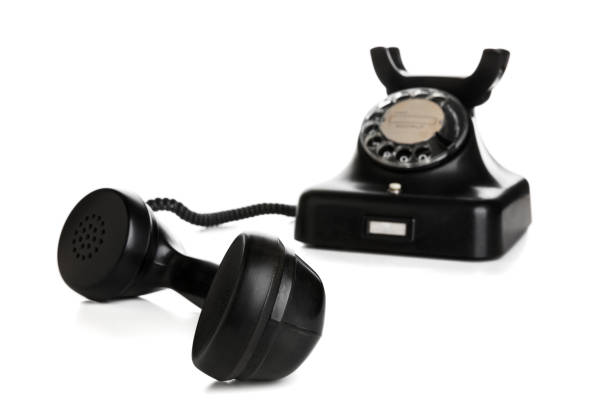 Vintage black telephone with receiver off-hook isolated on white background, selective focus