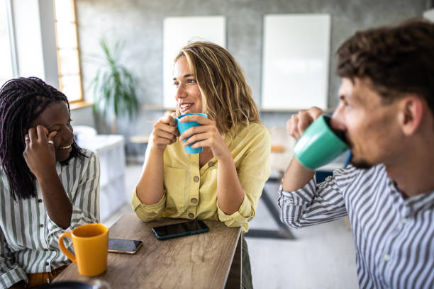 Coworkers enjoying coffee break in open space workplace