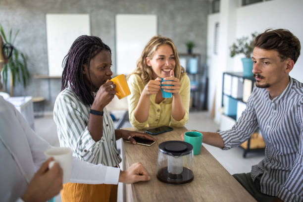 istock Coworkers enjoying coffee break in open space workplace 1334659931