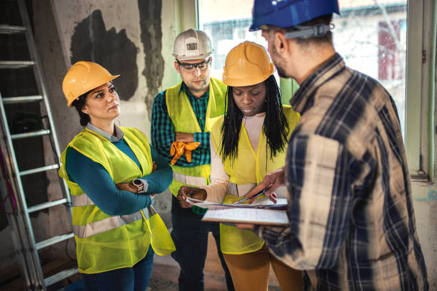 istock Engineers and architects looking at building blueprint at the construction site 1334660119