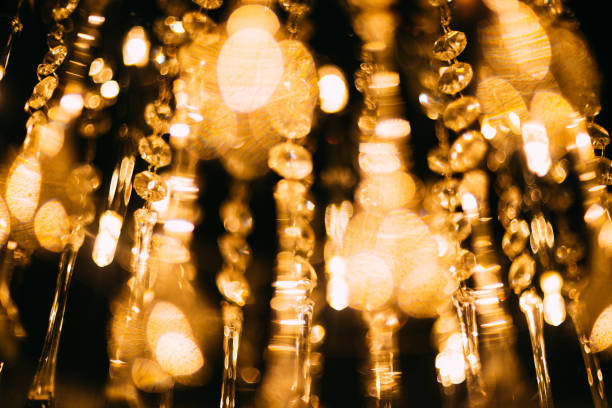 istock Blurred abstract background of crystal glowing spheres chandeliers. Warm light . 1334660252