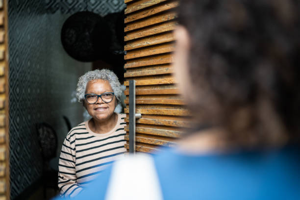 Senior woman open door to healthcare worker arriving at home Senior woman open door to healthcare worker arriving at home neighbour stock pictures, royalty-free photos & images