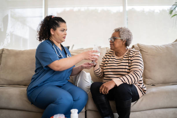 istock Nurse helping senior patient taking medicines at home 1334660936