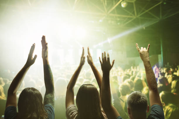 erhobene hände vieler menschen zu ehren einer musikalischen show auf der bühne. menschen in der halle - crowd noise flash stock-fotos und bilder