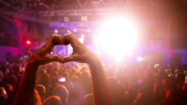 amor a la música. manos masculinas en forma de corazón y multitud o público en concierto de música en vivo - crowd noise flash fotografías e imágenes de stock