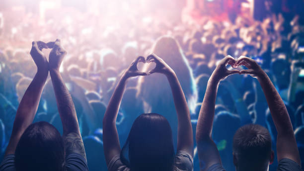 amor a la música. manos en forma de corazón masculino y femenino y multitud o público en concierto de música en vivo - crowd noise flash fotografías e imágenes de stock