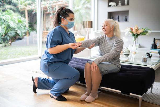 istock Physical theraphist supporting senior woman doing arm exercise at home 1334662843
