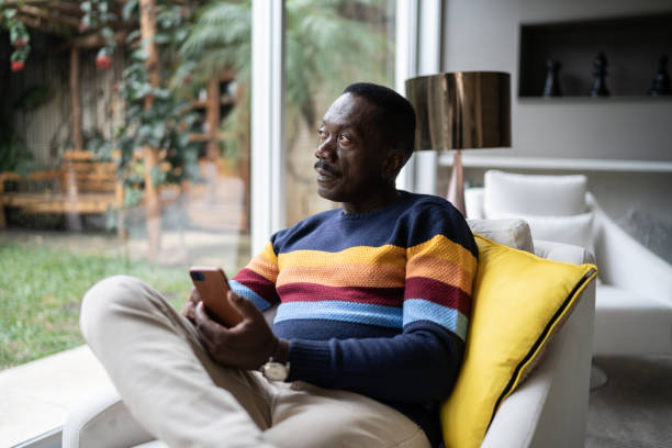 istock Senior man contemplating and using smartphone at home 1334662865