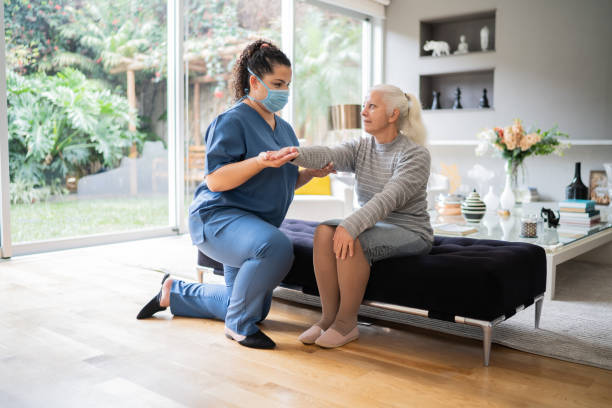 istock Physical theraphist supporting senior woman doing arm exercise at home 1334662880