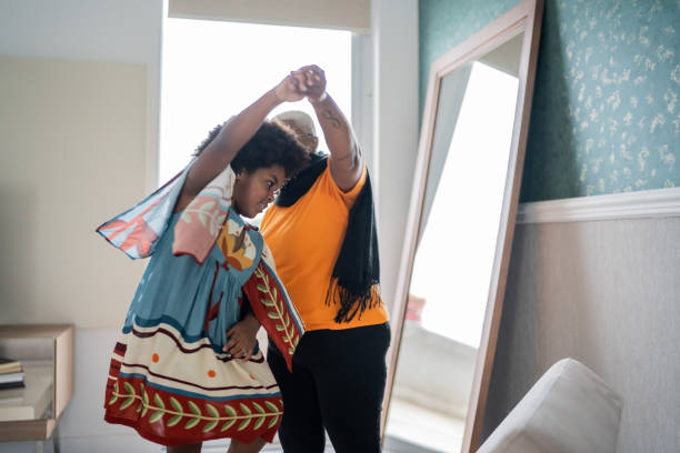 istock Mother and daughter dancing at home 1334663157