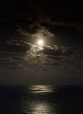 Moon over the sea with dramatic clouds