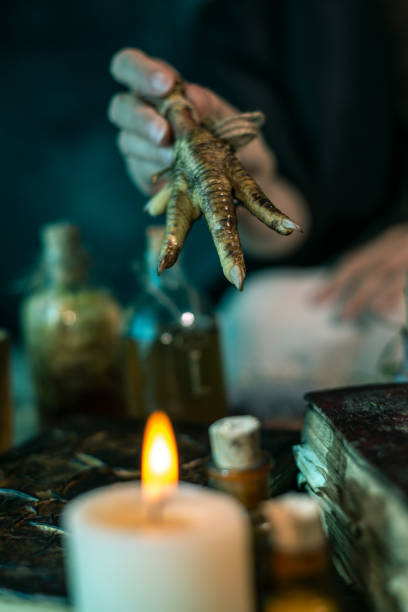istock Dark Witch at work: black magic woman makes the witchery by mixing herbs, casting the spells, running magic rituals 1334666524