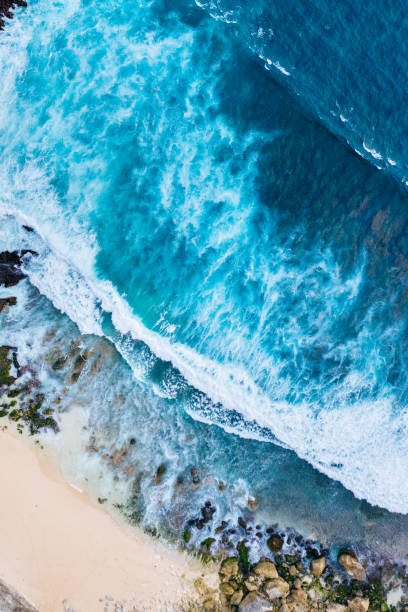istock Ocean waves hitting a rocky beach and cliffs. View from above. 1334669961
