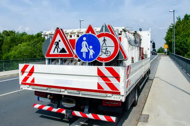 A worker's truck with roadsigns at a road construction site