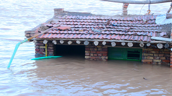 Close-up of a inundated house, only rooftop is above the water. Disasters, famines