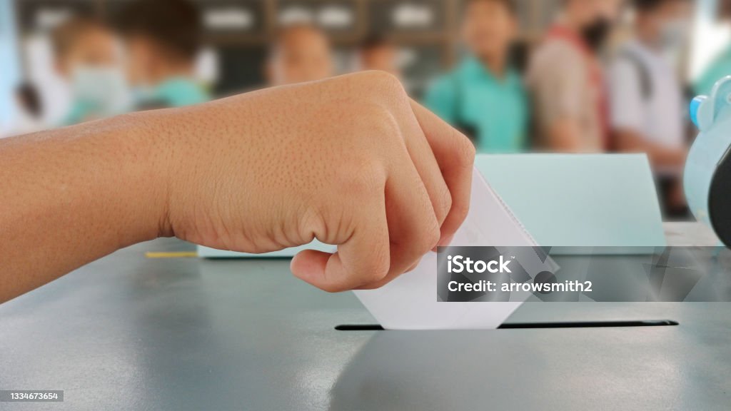 Students hands voting in the ballot box Voters on Election Day for the student council and the school board Voting Stock Photo