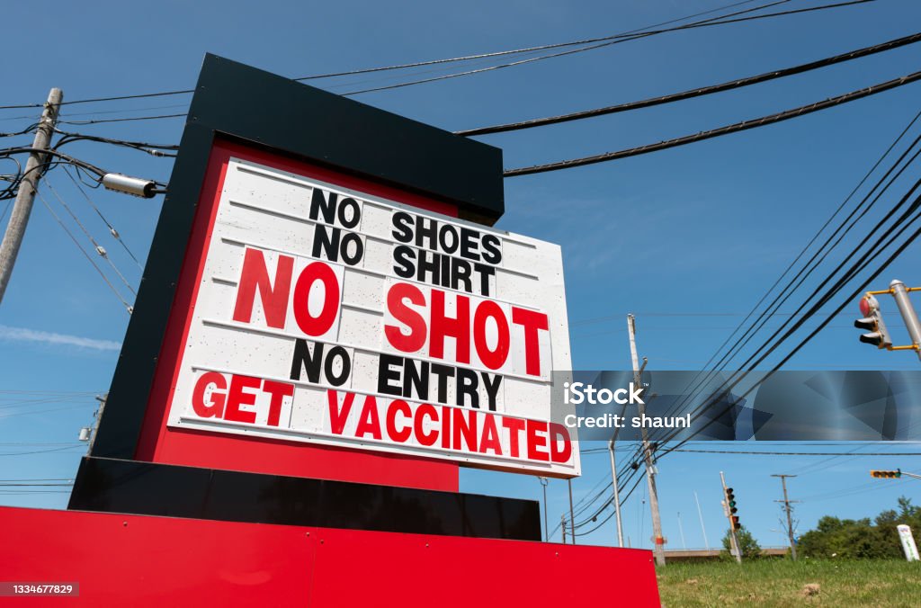 Retail Store Requires Vaccination Roadside signage for a store that requires the Covid-19 vaccination for entry. Anti-vaccination Stock Photo