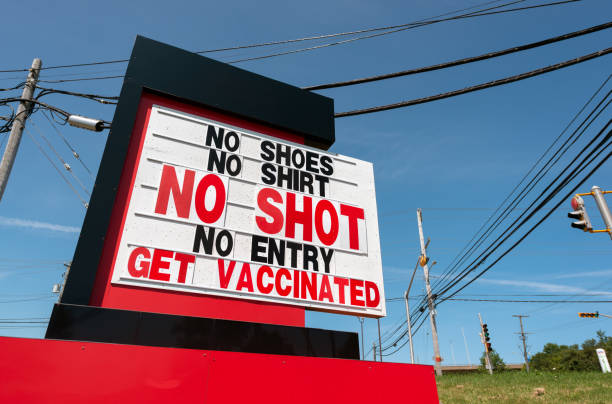 Retail Store Requires Vaccination Roadside signage for a store that requires the Covid-19 vaccination for entry. anti vaccination stock pictures, royalty-free photos & images