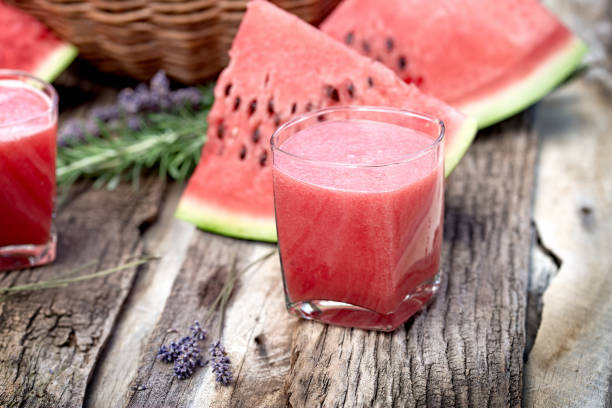 Watermelon smoothie and slices of watermalon on table