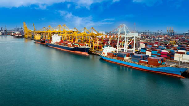 istock Logistic container ship from sea port warehouse with working crane bridge for delivery containers shipment. for transport or import export to global logistics concept. blue sky background 1334678802