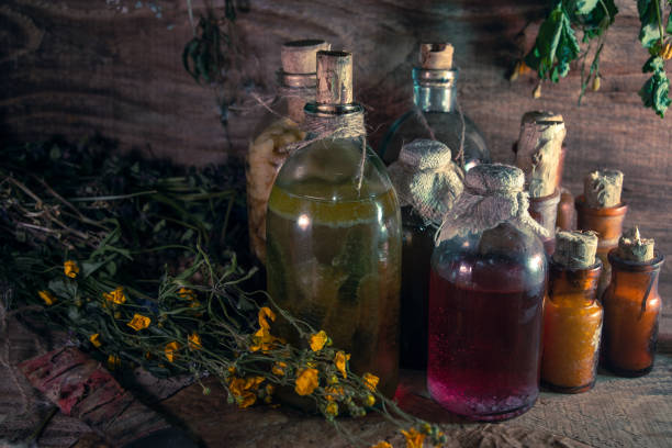 istock A witchery stuff: multiple tincture bottles, bunches of dry healthy herbs, stack of ancient ritual books, amulets, candles, runes chicken feet, sack of medicinal and magical herbs 1334678892
