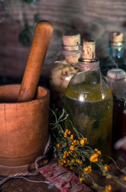 istock A witchery stuff: multiple tincture bottles, bunches of dry healthy herbs, stack of ancient ritual books, amulets, candles, runes chicken feet, sack of medicinal and magical herbs 1334678907