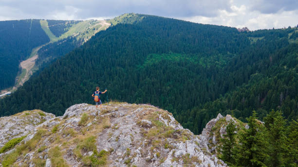 istock Adventurous school boy is standing mountain and enjoying the beautiful view during a vibrant sunset. Beautiful Nature Serbia Kopaonik natural landscape aerial photography 1334681818