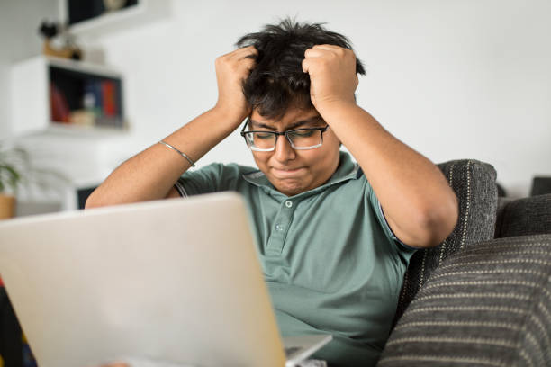 adolescente frustrato che usa il laptop - teenager laptop computer anger foto e immagini stock