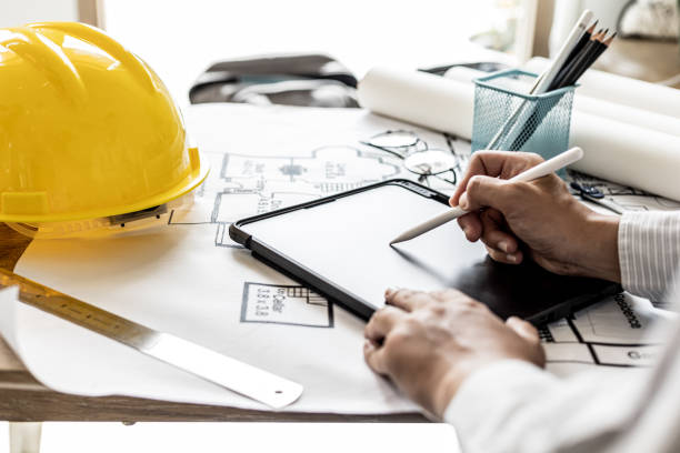 istock Architects are drawing house design blueprints, designing the house according to the needs of the homeowner and in accordance with the construction standards. Home design ideas. 1334683020
