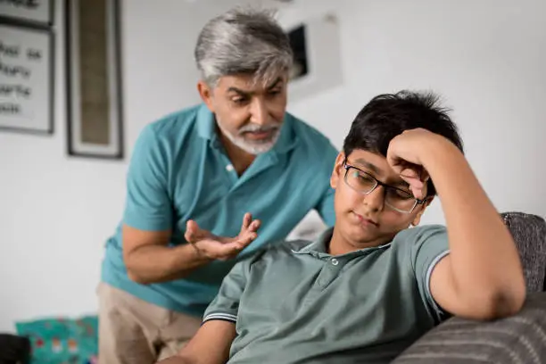 Photo of Frustrated father scolding his son