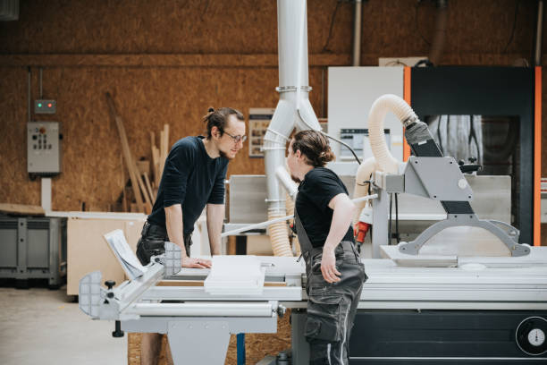 istock two young carpenters talking together at circular saw machine in workshop 1334683804
