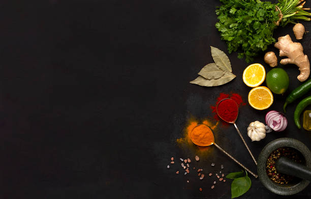 istock Concept, fresh herbs, ginger, lemon, lime, paprika, curry, spice mortar, top view, on a dark table, horizontal, no people, 1334684119