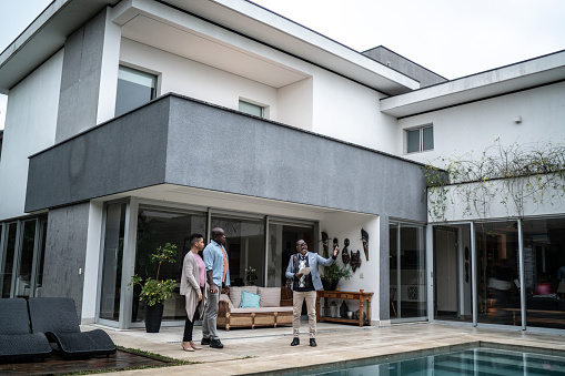 Real estate agent showing new house to customers