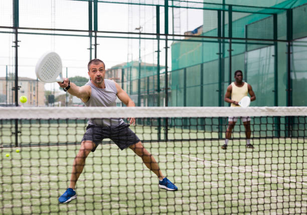 istock Athletic mens plays padel. View through tennis net 1334686467