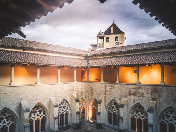 Interior view of the cloister of Ambronay Abbey in France in autumn weather Cloister of Ambronay Abbey interior view. This color photo was taken outdoor in the small village of Ambronay near Bugey mountains, in Ain departement, Auvergne-Rhone-Alpes region in France, in Europe, shot during a cloudy autumn day. abbey stock pictures, royalty-free photos & images